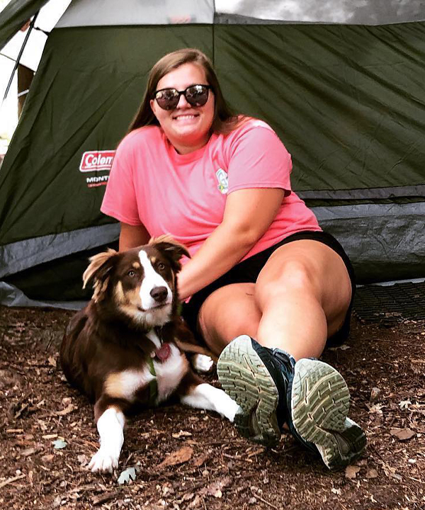 Katie Gestiehr outside by tent with dog